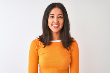 Young beautiful chinese woman wearing orange t-shirt standing over isolated white background with a happy and cool smile on face. Lucky person.