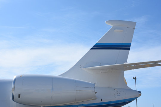 Close up of jet engine and tail of a private jet.