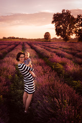 Mom and son walking in a lavender field at sunset