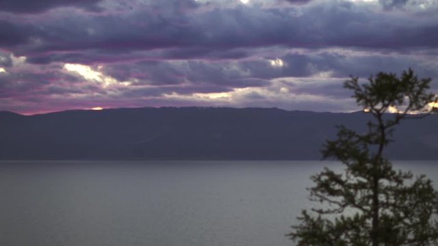 Beautiful sunset over Lake Baikal with Olkhon Island in the background.