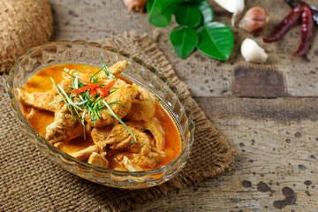 Panaeng Curry with chicken breast in bowl glass on wood background