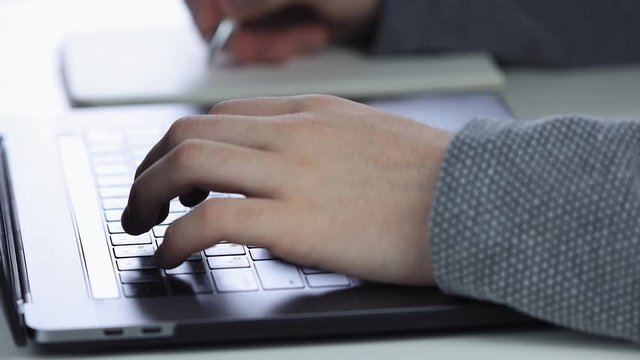 Men hands with  using laptop to work study and writing on paper with a pen. Business, financial, trade stock maket and social network concept.