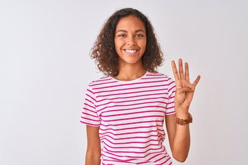 Young brazilian woman wearing pink striped t-shirt standing over isolated white background showing and pointing up with fingers number four while smiling confident and happy.