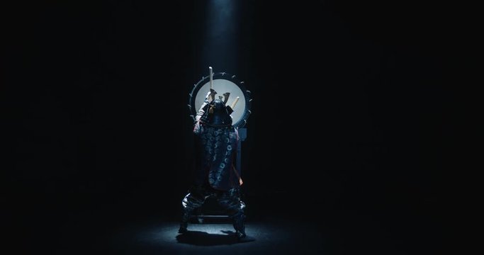 Japanese man in historical samurai costume playing on taiko drum with kata moves, isolated on black background - culture, history concept 4k footage