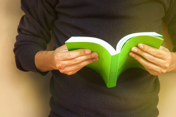 Man reading a book with green cover