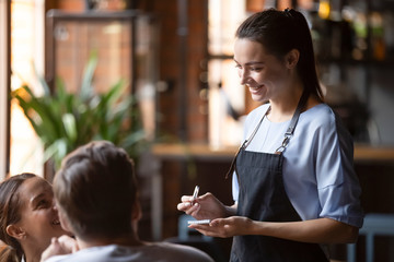 Smiling female waitress take order talk to clients couple - obrazy, fototapety, plakaty