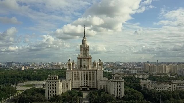Aerial view of the famous Moscow State University high rise, surrounded by greenery and city buildings, in sunny weather