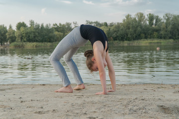  child doing bridge exercise on the beach.