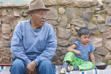 Sad native american old age man and little boy with a bowl.
