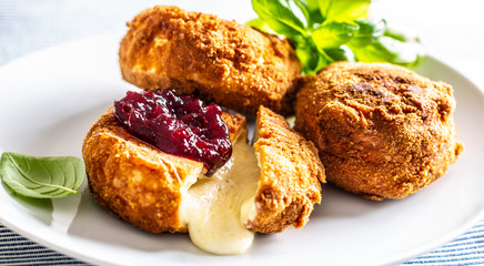 Fried camembert or brie cheese with cranberry jam and basil