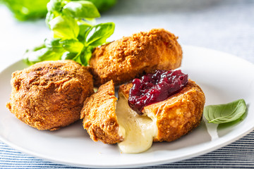 Fried camembert or brie cheese with cranberry jam and basil