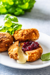 Fried camembert or brie cheese with cranberry jam and basil