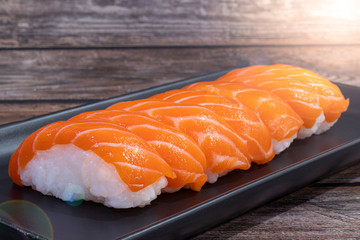 Salmon sushi on wooden background, Japanese style, Slices of raw salmon fillet.