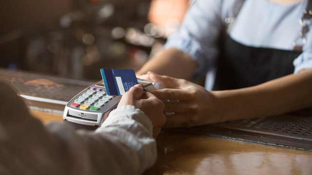 Female customer holding credit card near nfc technology on counter