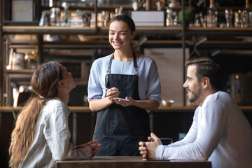 Smiling waitress hold notepad take order serving couple customers - obrazy, fototapety, plakaty