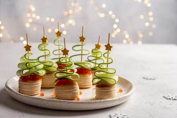 Christmas tree canape with cucumber slice, salmon pate and red caviar for festive xmas snack