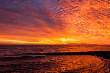 Obraz premium amanecer rojo en la playa