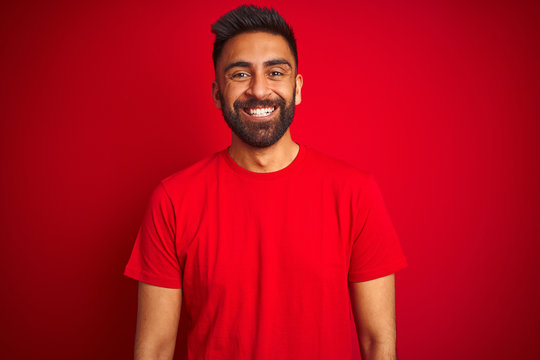 Young Handsome Indian Man Wearing T-shirt Over Isolated Red Background With A Happy And Cool Smile On Face. Lucky Person.