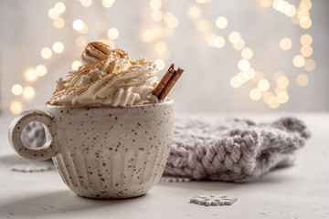 Hot chocolate with cream and cinnamon stick in a ceramic cup. The concept of winter time.