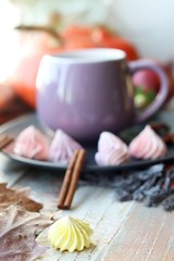 Cup of coffee, meringues, pumpkins, leaves, plaid on a window background, home comfort concept, Thanksgiving, autumn season