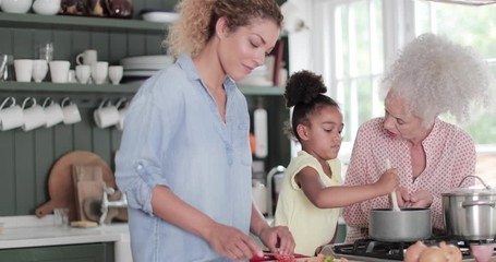 Three generations of family cooking a meal together