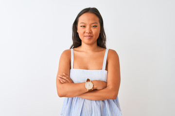 Young chinese woman wearing casual striped dress standing over isolated white background skeptic and nervous, disapproving expression on face with crossed arms. Negative person.