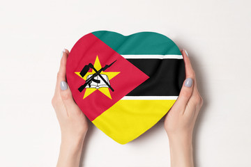 Flag of Mozambique on a heart shaped box in a female hands. White background