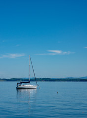 Fototapeta premium lone sailboat moored in a bay