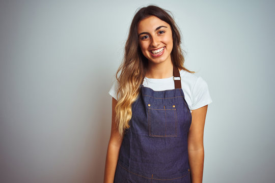 Young beautiful woman wearing apron over grey isolated background with a happy and cool smile on face. Lucky person.