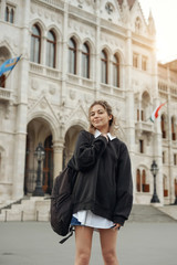 Fototapeta na wymiar Casual woman student enjoying great view of the Parliament building in Budapest city, travel in Europe concept