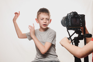 Boy enthusiastically sings in front of the camera. Children's hands with a camera in the frame....