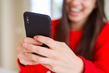 Young woman using smartphone, smiling happy texting and typing