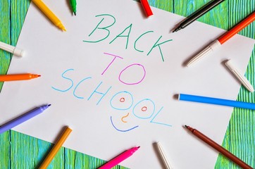 Creative idea depicting the return of children to school. School markers and a card with the text back to school.