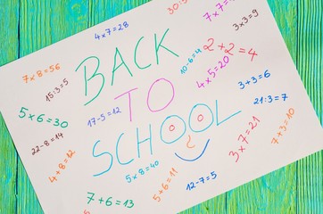 Creative idea depicting the return of children to school. White paper with mathematical operations and text back to school.