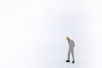 Close up of business,am miniature figure standing and walking on white background with copy space for text.