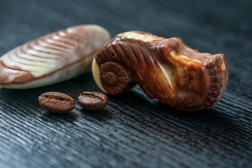 Belgian chocolates on a black wooden background. Photographed close-up.