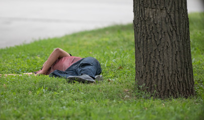drunk homeless man sleeping on the lawn