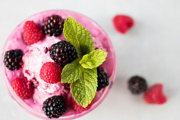 Homemade sorbet made from fresh berries with mint in glass bowl on a gray background. Soft focus.