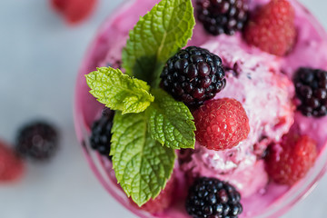 Homemade sorbet made from fresh berries with mint in glass bowl on a gray background. Soft focus.