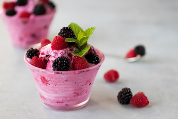 Homemade sorbet made from fresh berries with mint in glass bowls on a gray background. Soft focus.