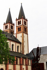 Vertical view of the Würzburg Cathedral along with the art of a metal sculpture, photograph taken in Würzburg, Germany.