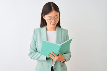 Fototapeta premium Young chinese student woman wearing glasses reading book over isolated white background with a happy face standing and smiling with a confident smile showing teeth
