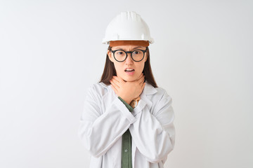 Young chinese engineer woman wearing coat helmet glasses over isolated white background shouting and suffocate because painful strangle. Health problem. Asphyxiate and suicide concept.