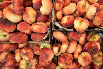 Fig peach, flat peaches at farmer's market or grocery shelves. Top view, background for agriculture news or illustration.