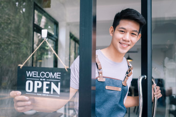 Young startup coffee cafe owener open and welcome customer.