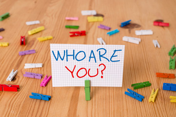Text sign showing Who Are You question. Business photo text asking about demonstrating identity or demonstratingal information Colored clothespin papers empty reminder wooden floor background office