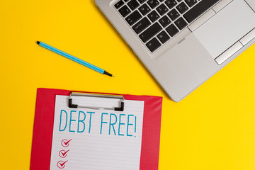 Writing note showing Debt Free. Business concept for does not owning any money or things to any individual or companies Trendy metallic laptop clipboard paper sheet marker colored background