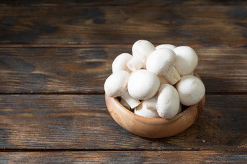 Mushrooms in a wooden bowl on a wooden table