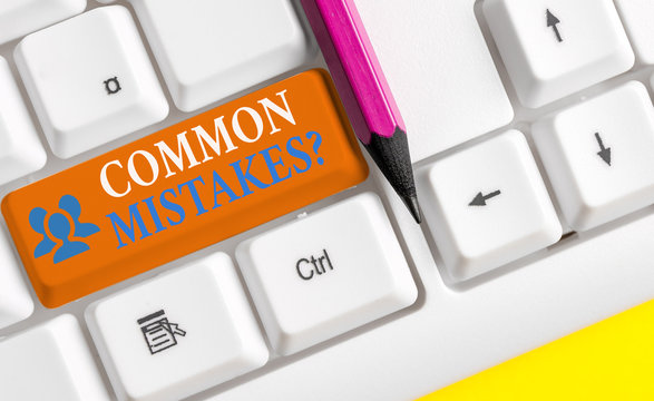 Writing note showing Common Mistakes question. Business concept for repeat act or judgement misguided or wrong White pc keyboard with note paper above the white background
