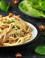 Pasta with roasted walnut, ricotta white pesto sauce, parmesan cheese and spinach
